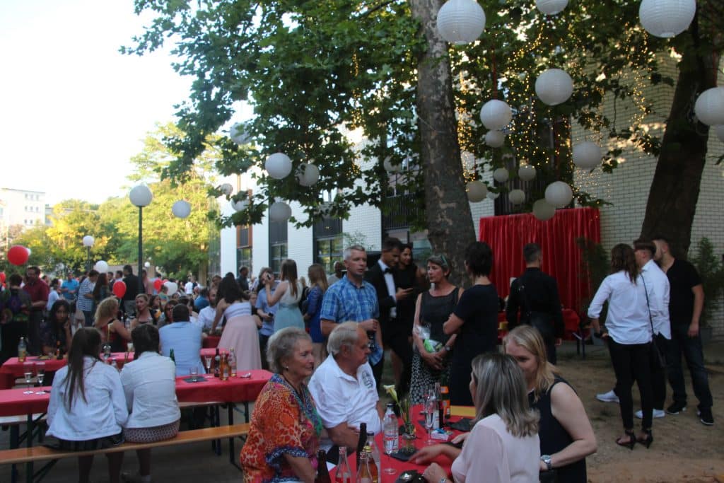 Geselliges Event im Freien mit Gästen und festlicher Dekoration.
